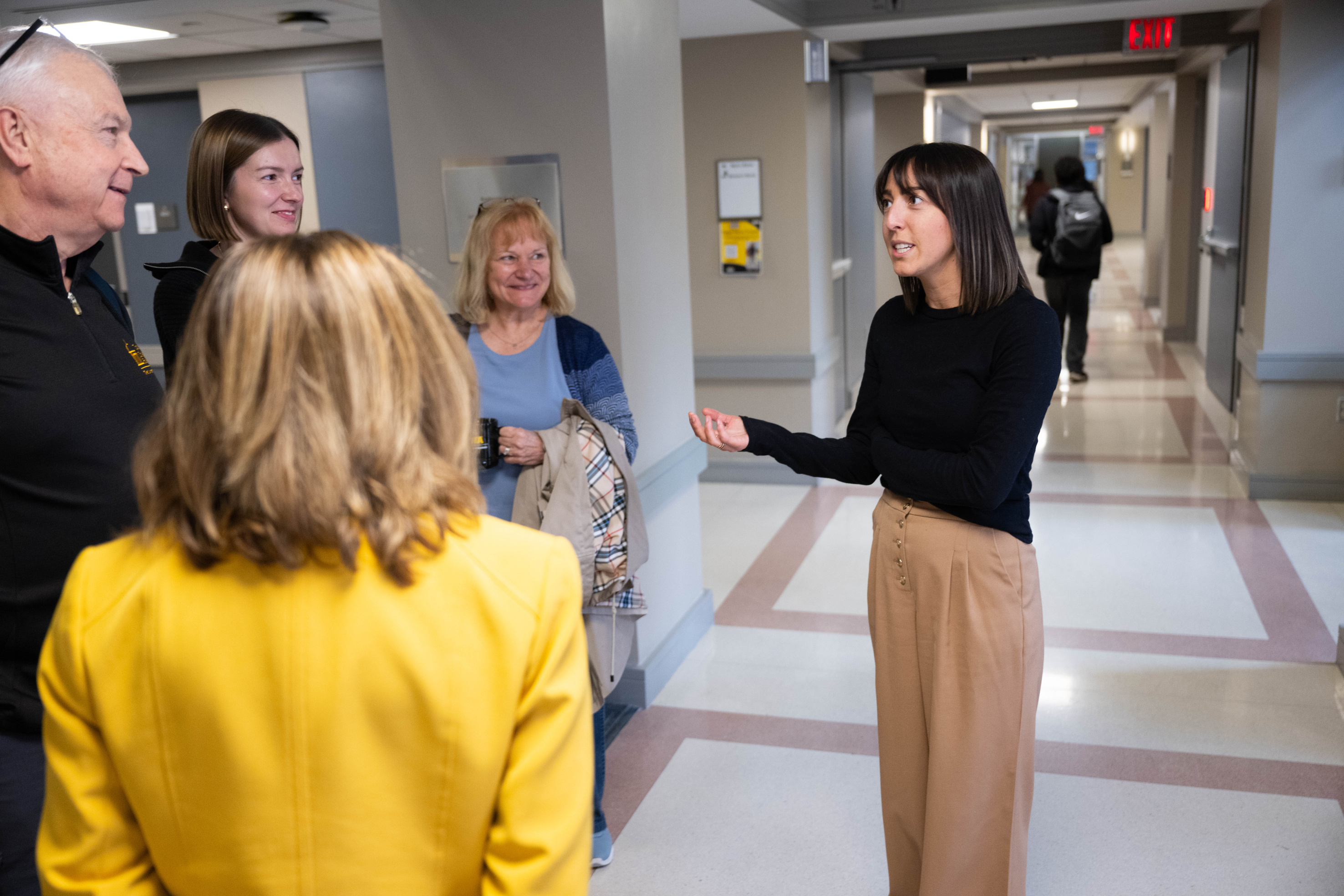 Emily Campion having a discussion with colleagues in the hallway