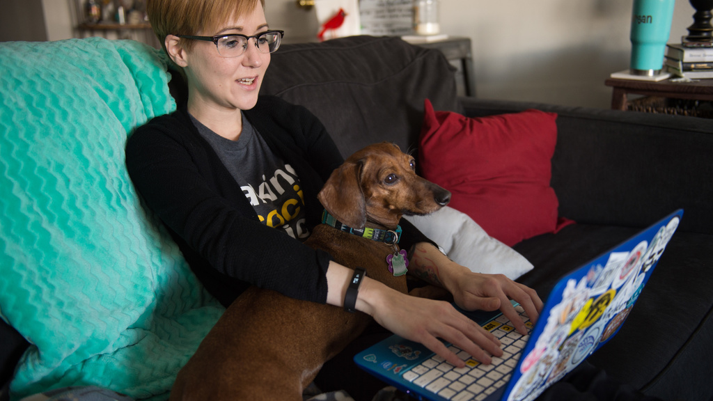 Online Masters in Social Work student working on her laptop (with her dog).